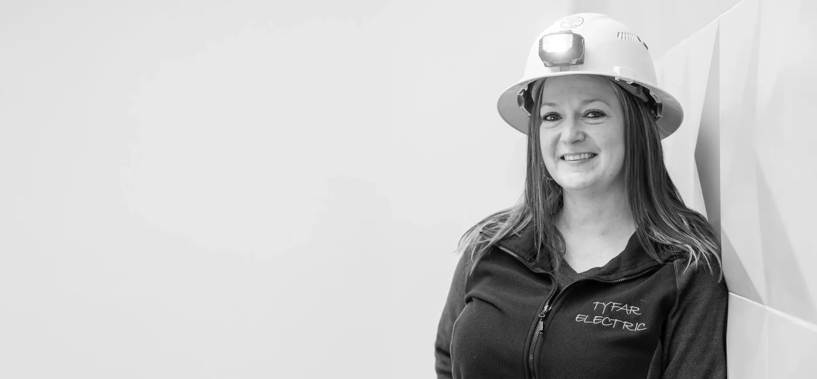 woman smiling with hardhat on